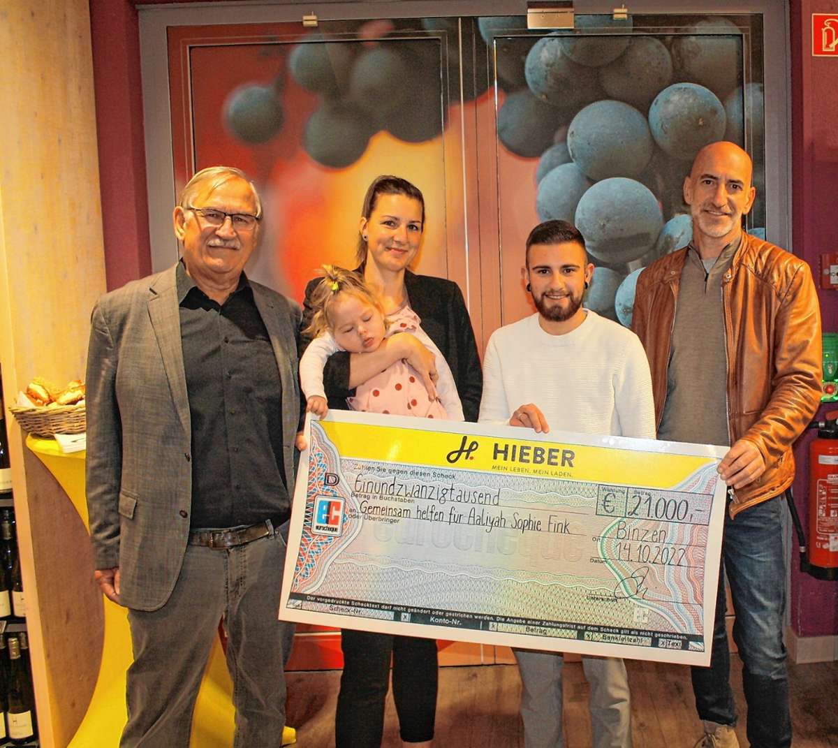 Ulrich May (links) und Dieter Hieber (rechts) überreichten Tanja und Luca Fink mit Aaliyah einen Scheck über 21 000 Euro. Foto: Christoph Schennen