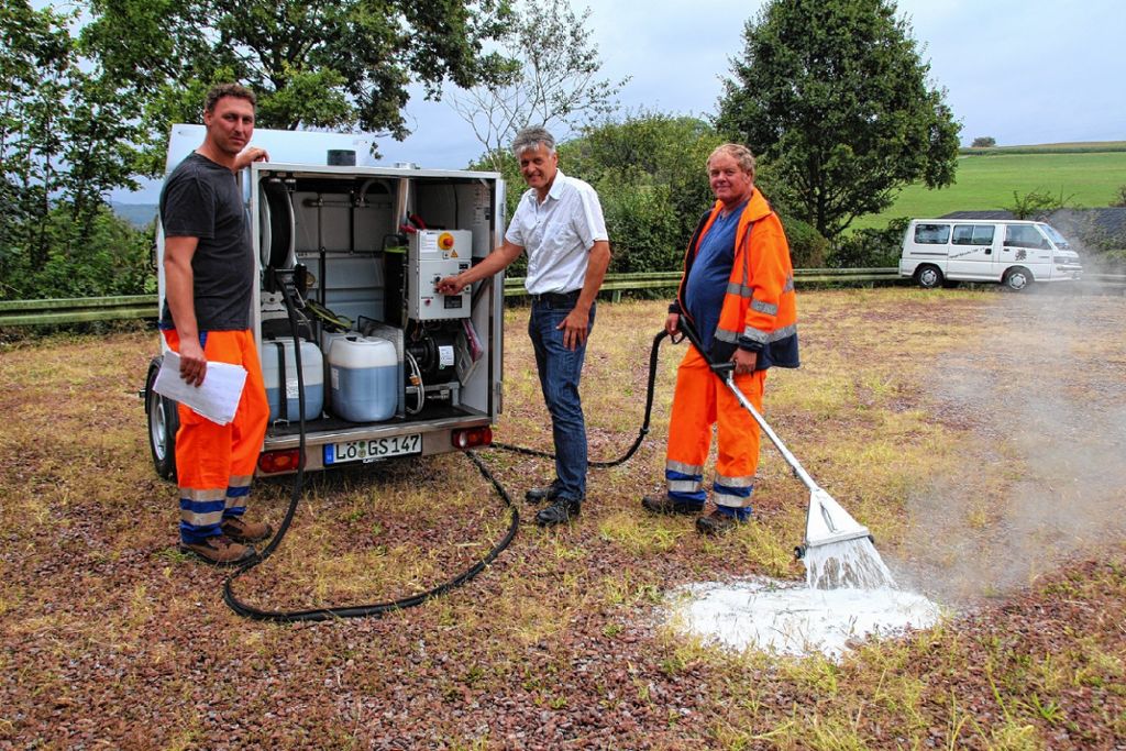 Bürgermeister Gunther Braun sowie Martin Stobbe (links) und Jürgen Walliser (rechts) stellten gestern in Hüsingen das neue Heißwasser-Schaumsystem zur ökologischen Unkrautbekämpfung vor  Fotos: Harald Pflüger