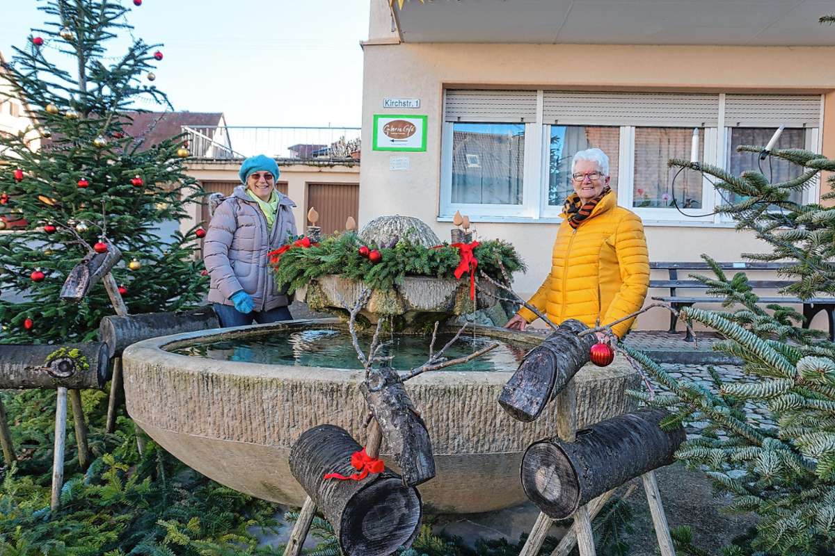 Ein prächtiger Adventskranz auf dem Wasserstein: Silvia Heitz (l.) und Monika Morath am weihnachtlich geschmückten Storchenbrunnen. Die Tannenbäume hat die Gemeinde zur Verfügung gestellt.