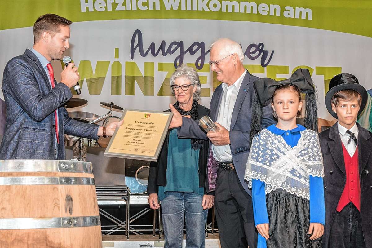 Bürgermeister Ulli Waldkirch überreicht das Auggener Viertele an Ernst Giesel sowie Blumen an dessen Frau Barbara Holdermann.