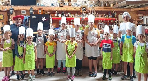 Viel Spaß und doch auch Wissensvermittlung bot „Luigi“ Daniele Maula (links) mit Unterstützung von Tobias Hohenstatter den Koch-Kindern beim Ferienprogramm. Foto: Ralph Lacher