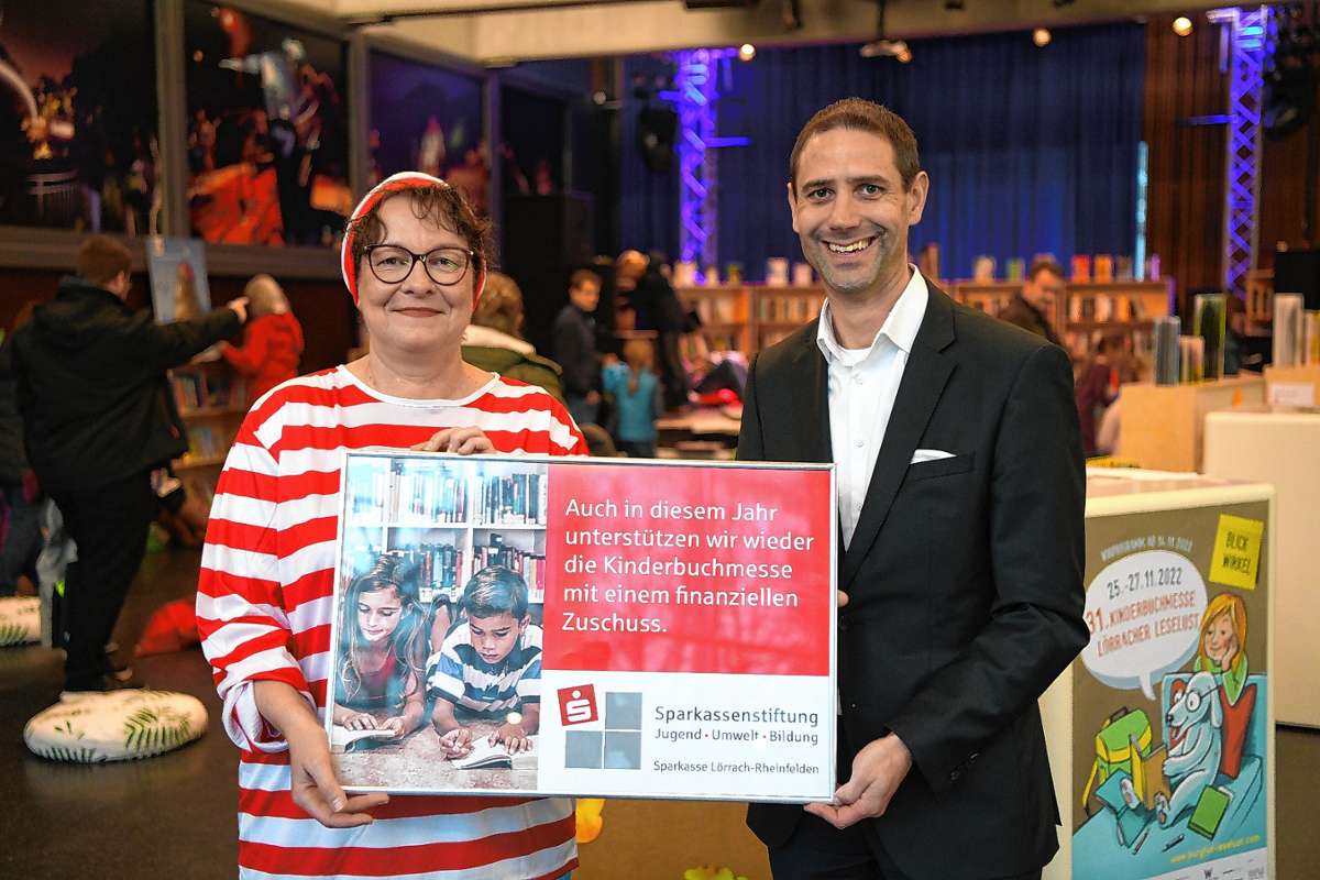 Christian Eschbach, Vorstandsmitglied und Vertreter der Sparkassenstiftung Jugend, Umwelt, Bildung, überreicht eine Spende an die Leiterin der Kinderbuchmesse, Birgit Degenhardt.