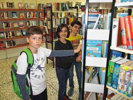 Lesen sehr gerne: Die Grundschüler aus der Hans-Thoma-Schule (von links) Laur Krasniqi sowie die Geschwister Lulia und Lais Yaghchi profitieren wie auch viele weitere Schüler von der Bücherei. Foto: Renate Wendt