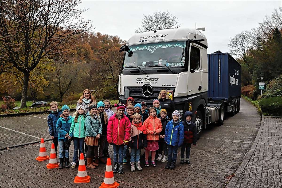 Lkw-Fahrerin Stefanie Fechtig (hinten rechts) und ihr acht Tonnen schwerer Truck „Prinz“ übten mit den Schülern an der Erstelhalle, wie gefährlich der tote Winkel ist. Foto: Rolf Rombach