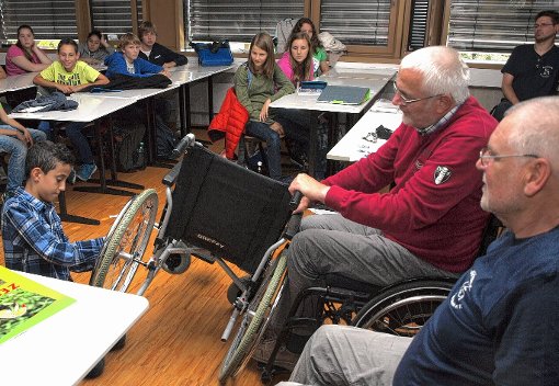 Gar nicht so einfach war es für die Oberrhein-Gymnasiasten,  mit einem Rollstuhl  über  eine kleine  Rampe zu fahren.  Marcel Langensieper gibt dazu entsprechende   Tipps, wie das Hindernis gemeistert werden kann.    
Foto: dz Foto: Weiler Zeitung