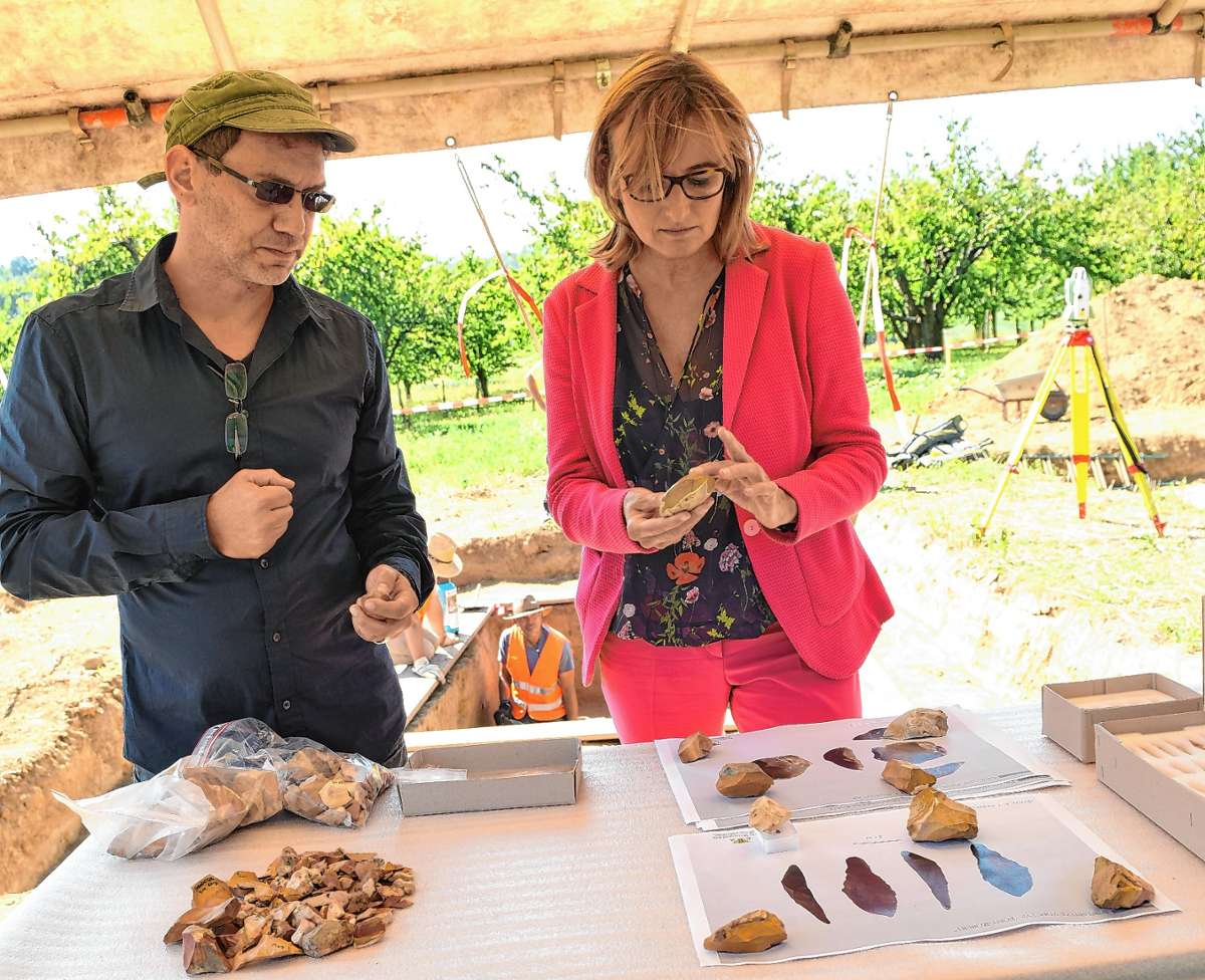 Grabungsleiter Marcel El-Kassem und Staatssekretärin Katrin Schütz mit Werkzeugen aus Feuerstein