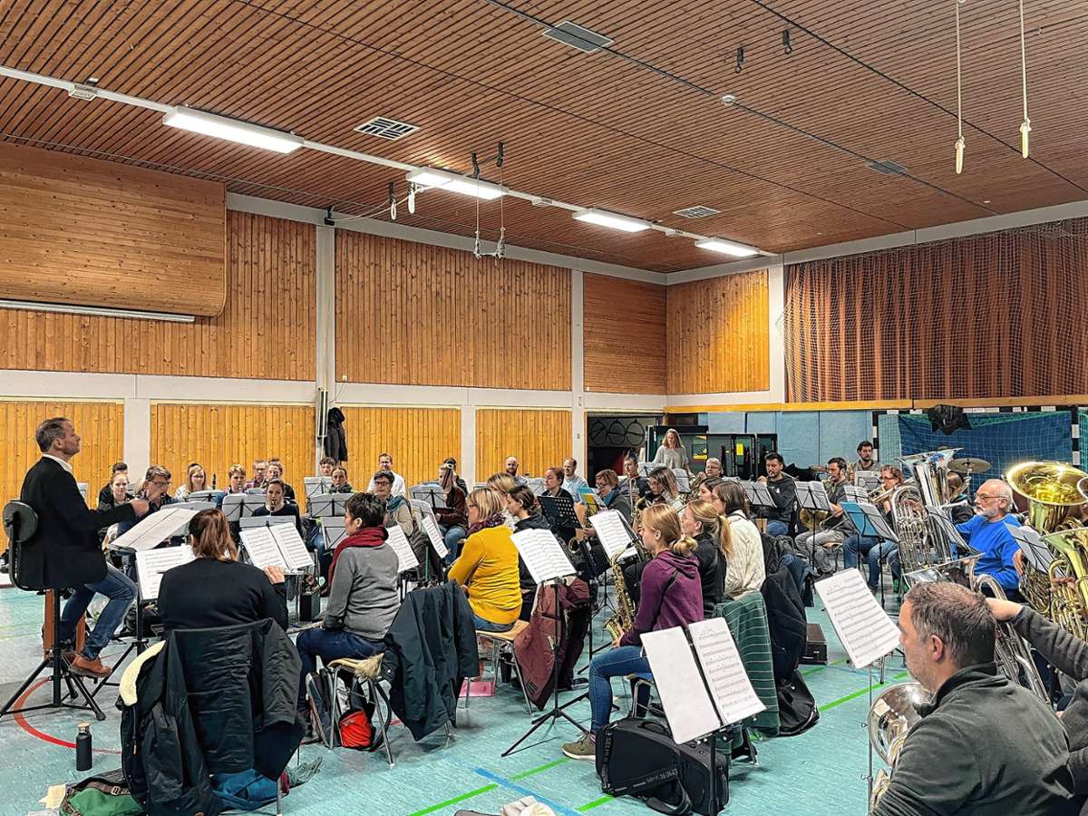 Oliver Hauser ist seit 1996 Dirigent des Musikvereins Wollbach. Rechts das Orchester bei einer Probe für das aktuelle Programm in der Wollbacher Kandertalhalle, die bei den Aufführungen mit 370 Plätzen bestückt sein wird. Foto: zVg/Musikverein